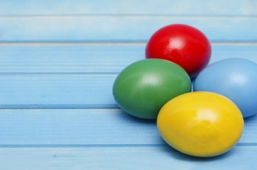 Naklejka na ściany i meble Easter eggs on blue wooden background 