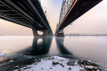 Winter scenery. Two parallel bridges over frozen river. Kiev. Ukraine.
