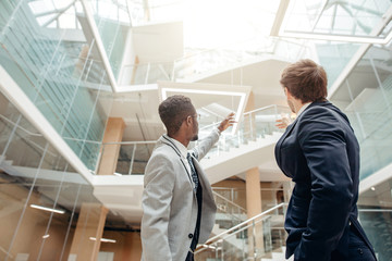 shot of afroamerican estate agent with potential client inside an empty office space © alfa27