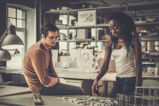 Multiracial couple working in design and engineering architecture office.