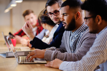 Young colleagues discussing ideas in coworking office.