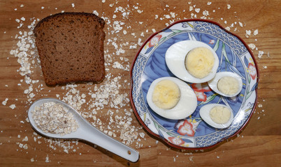 chicken and quail eggs on a blue saucer and oat chips and a piece of black bread