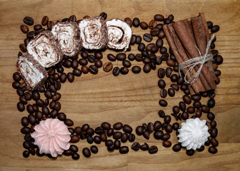 meringue and cinnamon stick and coffee beans and turkish delight on a broun wooden table