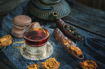 A Cup of brewed black tea. Two ceramic spatulas with caramel sugar and Rolled leaves in a large pearl. Chinese tea from Yunnan. Bi Lo Chun.