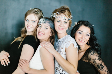 Young beautiful women with a beautiful diadem in their hair poses on dark background.