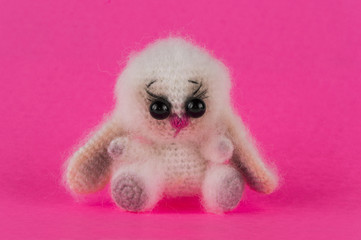 Fototapeta premium knitted toy bunny on a pink background