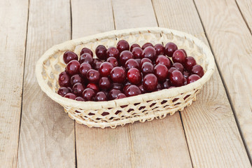 Ripe juicy cherries backet on  wooden background