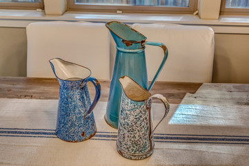 Vintage enamel pitchers on farmhouse table