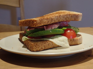 Toasted sandwich containing bacon, avocado, lettuce and tomato