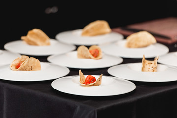 Hand of a girl puts tomato in tacos. The chef at the restaurant is going to make Spicy Shrimp Tacos with Coleslaw and Salsa.