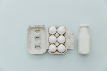 Fototapeta na wymiar Fresh milk, eggs over pastel background. Dairy products minimal fat lay