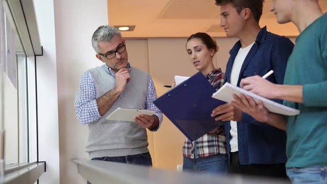 Teacher in classroom teaching economics to young adults