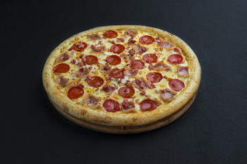 Hot homemade pepperoni pizza ready to eat on black background