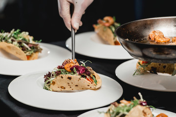 The chef at the restaurant making Spicy Shrimp Tacos with Coleslaw and Salsa