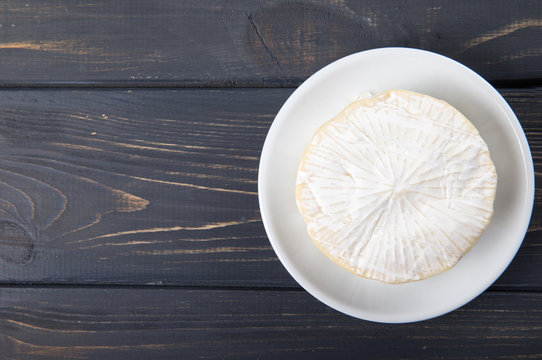 cheese camembert, on a wooden background.