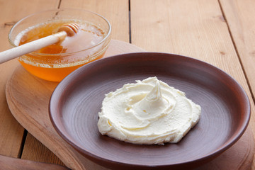 Sour cream, cream, fresh sour cream in pottery on a wooden background, dairy products and honey, wooden board, French breakfast, healthy food, sour cream and honey in a rustic style, minimalism, copy 