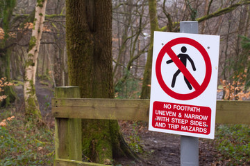 a warning sign informing of the uneven trail that lays ahead 