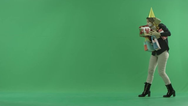 Attractive young woman with a pile of birthday presents, green chroma key background