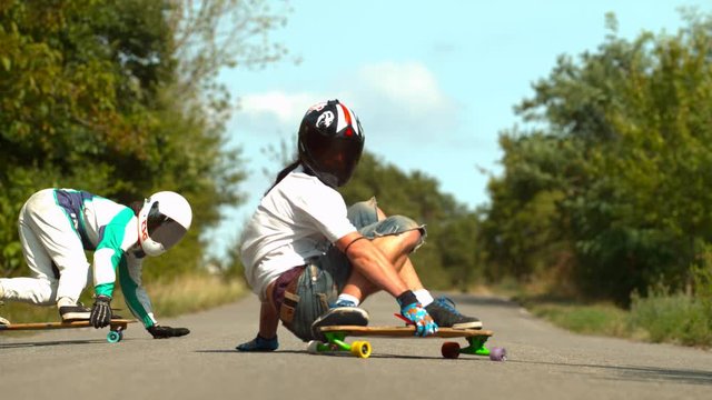 Two people longboarding on the road, slow motion