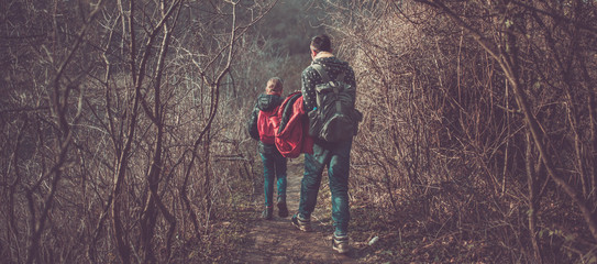 Father and daughter hiking on forest trail