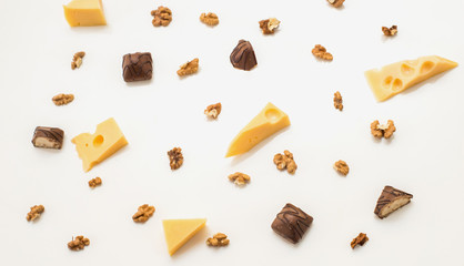 Pieces of cheese with Greek nuts on a light paper background. chocolate candy