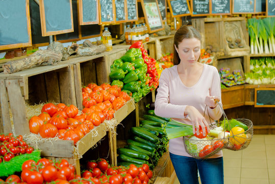 Lady in farm shop holding basket of produce