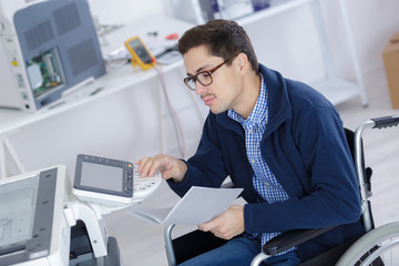 young disabled technician using printer in office