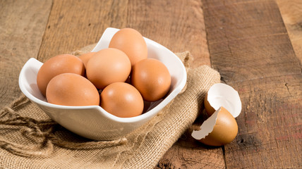 Freshly laid organic eggs in bowl on wooden bench