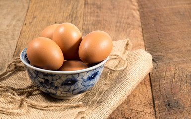 Freshly laid organic eggs in bowl on wooden bench