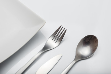 Metal inox cutlery on bright gray table