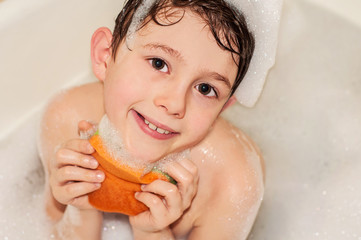 The boy himself washes himself in the bathroom with foam
