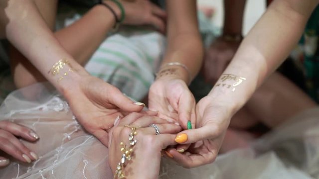 Women with golden tattoo bride team at hand