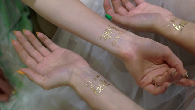 Women with golden tattoo bride team at hand