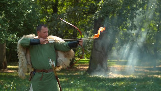 Ancient archer with flaming arrow, slow motion