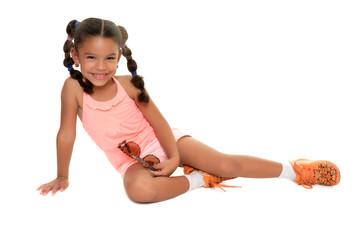 Cute multiracial small girl laying on the floor and smiling