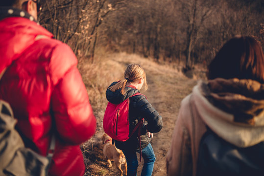 Family Hiking At Mountain With Dog