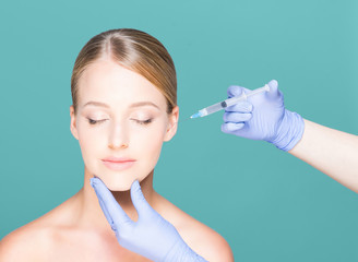 Doctor injecting in a beautiful face of a young woman. Plastic s