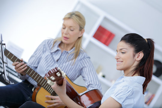 Young Woman Learning To Play Guitar