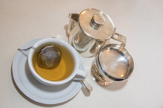 Tee in Tasse mit Teeei, Milch, Wasser, serviert, Tisch