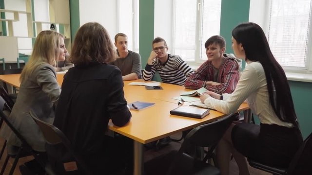 Female teacher talks with students during a lesson at university