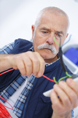 senior worker plugging socket type to electrical outlet