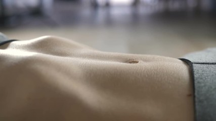 Extreme close-up of woman doing abdominal exercise indoors. Sporty female in sportswear top doing crunches at home on the floor. Sit ups as best exercise for abs. - Powered by Adobe