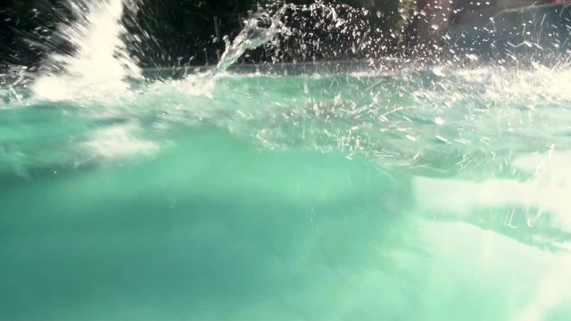 Woman in blue bathing suit swimming underwater in slow motion
