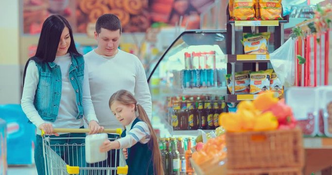 Mother, father and children picking out fruit in a package in supermarket
