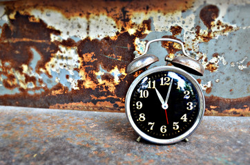 Retro clock on Iron table with a wall rust background