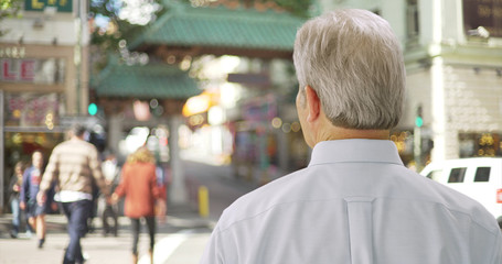 Portrait of senior white male looking at Chinatown entrance San Francisco