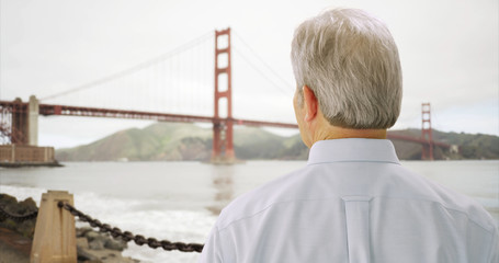 Mid aged male caucasian looking at golden gate bridge in San Francisco bay