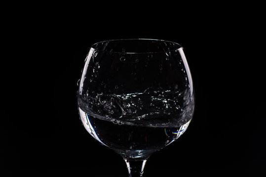 Water splashing out of a tall wine glass
