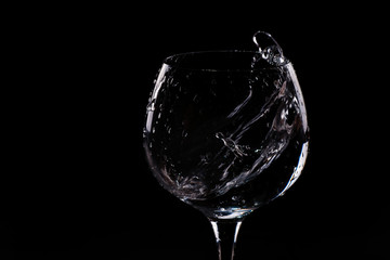Water splashing out of a tall wine glass