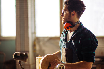 Young attractive man begin doing woodwork in carpentry